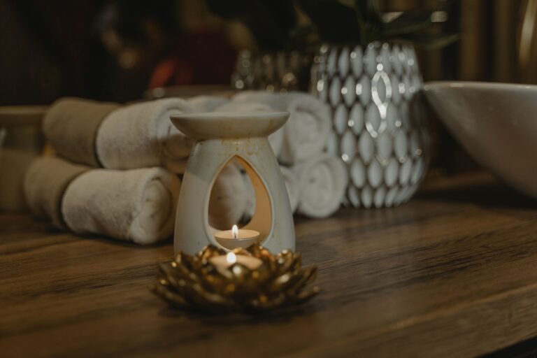Candle burning beside rolled towels in a calm treatment room