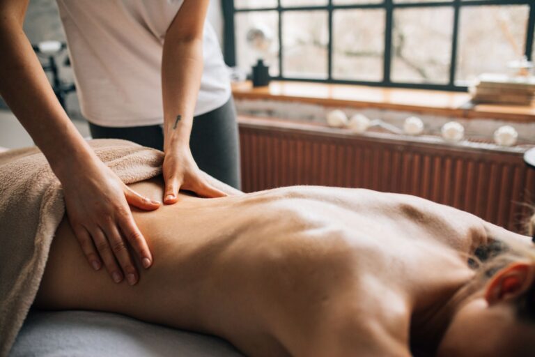 Massage therapist working on a client's back muscles during a remedial massage